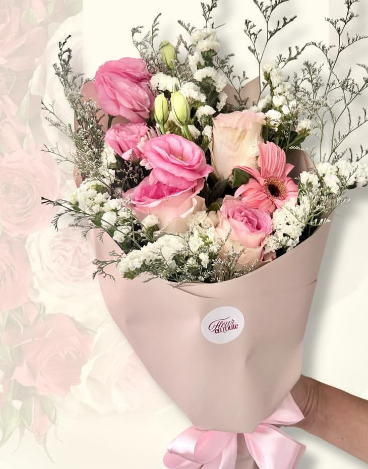 Loose pink and white bouquet with lisianthus, roses, and misty fillers in taupe wrap