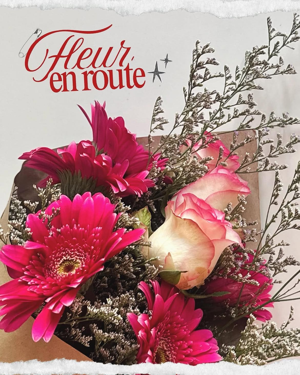 Fuchsia gerberas and a blush rose with dried caspia under the Fleur en Route logo