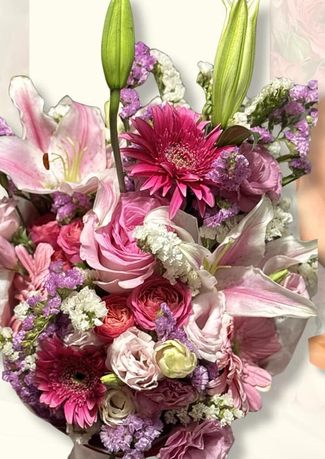 Pink bouquet with lily buds, fuchsia gerberas, and roses with lavender statice